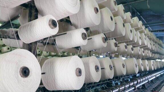 纺织厂机器的线轴在机架上用纤维缠绕纺织厂设备在工作