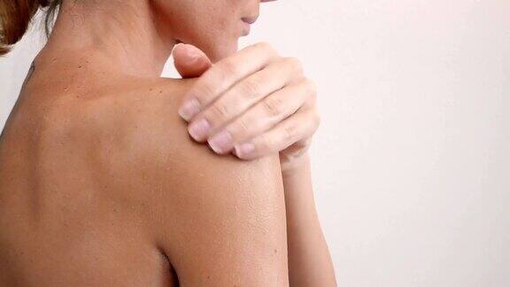 肩部和女性背部身体乳液蔓延缓慢动作特写