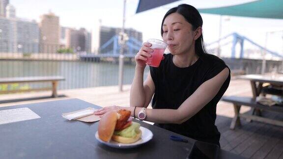 一位日本女子在河畔咖啡馆吃午餐
