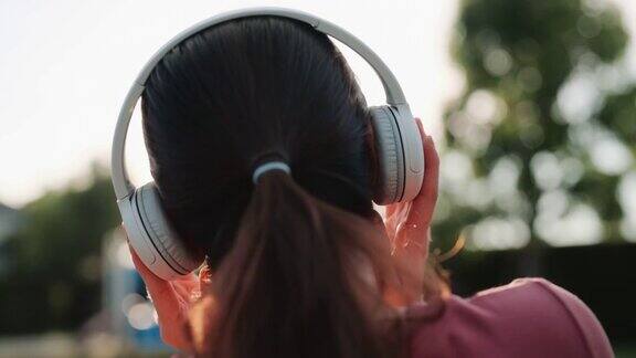 亚洲女人戴着耳机听音乐