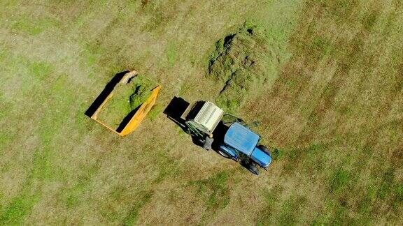 空中俯瞰现代拖拉机在农田割草