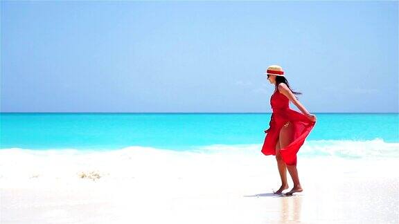 年轻美丽的女人享受假期在白色的热带海滩