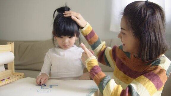 小女孩在母亲陪伴下做家庭作业