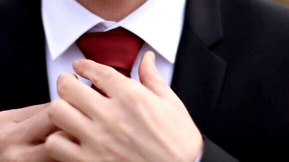 穿西装的男人正在系领带