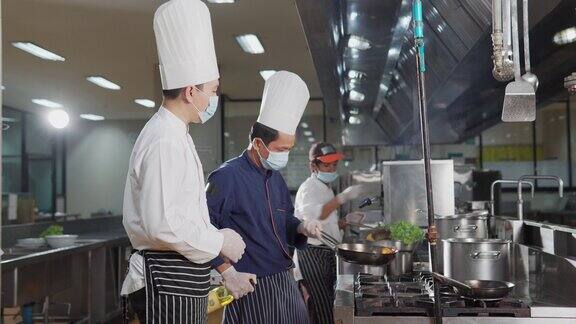 在酒店餐厅厨房里准备食物的厨师团队食物和丁克概念