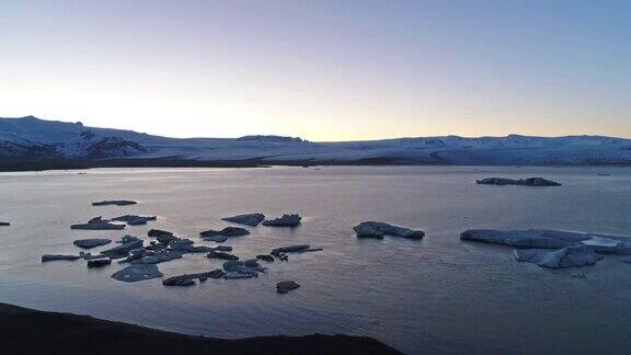 在冰岛南部海岸的Jokulsarlon泻湖上无人机在漂浮的冰山上空飞行