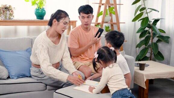 亲情温暖亚洲一家人在家里沙发上画画