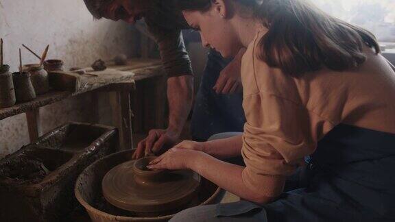 父亲在陶艺作坊里教女儿