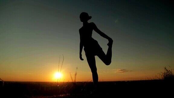 日落时分女人在公园里练习瑜伽舞姿之王