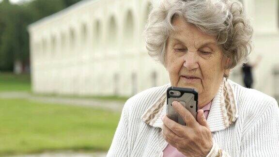 一位老妇人在用智能手机和朋友聊天