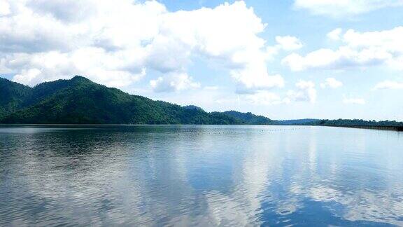 宁静的湖景和多云的天空和绿色的山背景