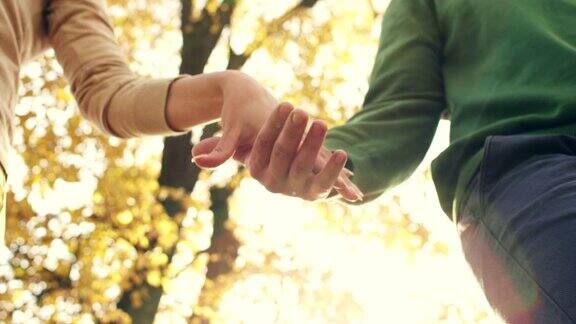 一对年轻夫妇在公园里牵着手