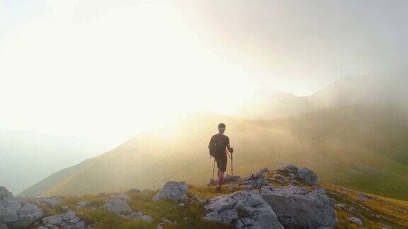 在日落时分一名年轻人在意大利阿布鲁佐山的山脊边缘徒步旅行