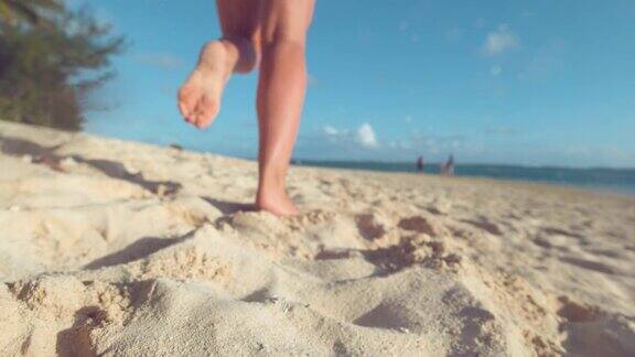 慢镜头:活跃的女游客赤脚慢跑在白色的沙滩上