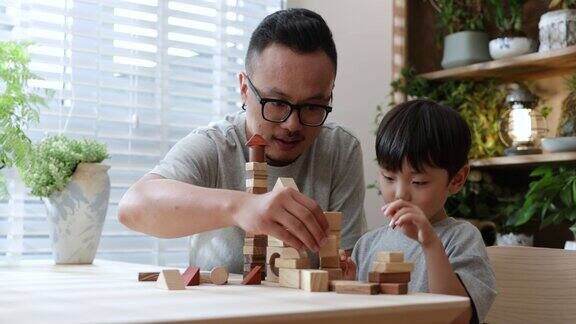 亚洲父亲和儿子在家里玩积木
