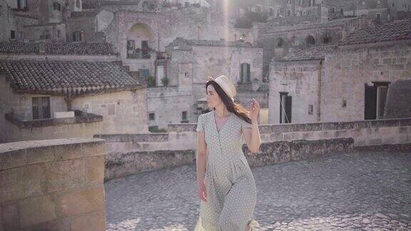 美丽优雅的年轻女子走在意大利马泰拉古城