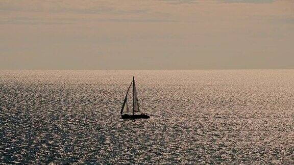 日落时地平线上的帆船、游艇