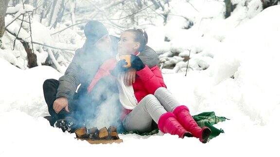 一对夫妇在冬天靠近篝火