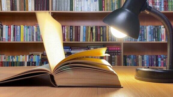 在图书馆的台灯下翻页的书籍