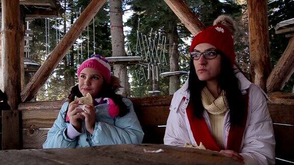 母女俩在滑雪休息时间吃三明治