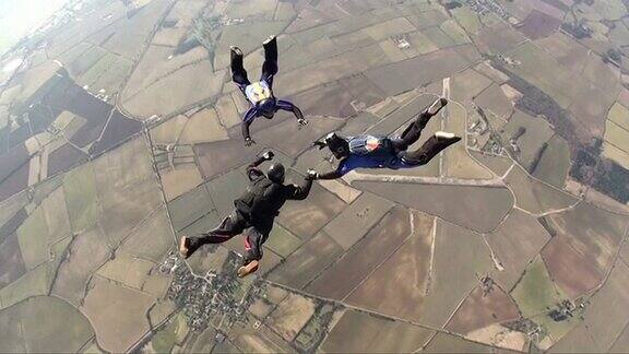 三名跳伞运动员在自由落体时做队形动作