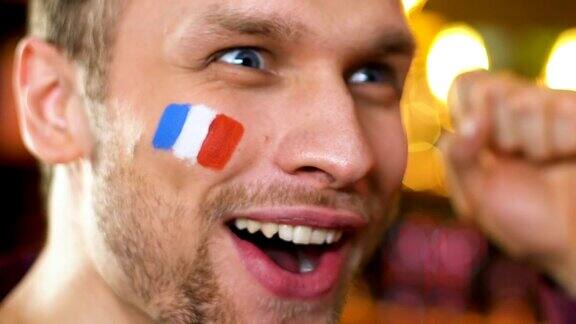 法国体育迷非常高兴最喜欢的球队赢得比赛国旗在脸颊上