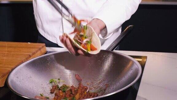 厨师为餐厅厨房准备晚餐的炒素菜用炒锅煮美味的素食在素食餐厅烹饪中做素食餐的人近距离