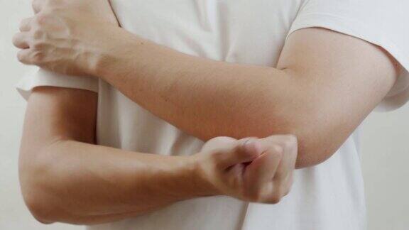 一名穿着白衬衫的亚洲男子感到肘部疼痛肌肉疼痛保健理念