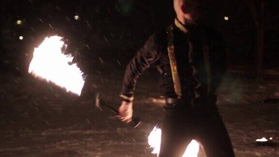 令人惊奇的部落篝火表演舞蹈在冬天的夜晚在飘落的雪舞团在雪天以火炬和烟火表演