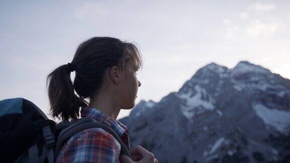 年轻女子站在山顶眺望着远方的群山