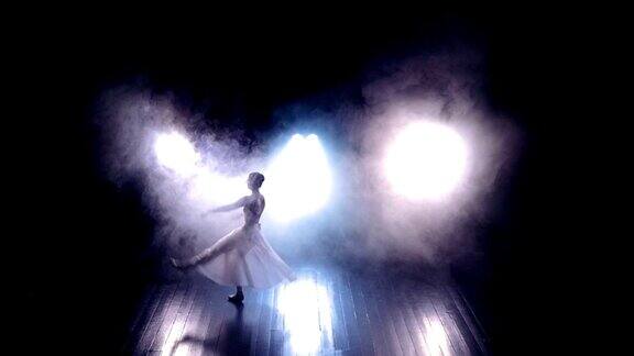 芭蕾舞演员在黑暗的舞台上进行跳高