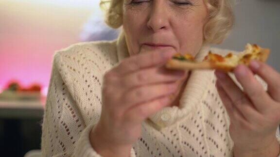 老年夫妇嚼着便宜的烧焦披萨营养不良快餐