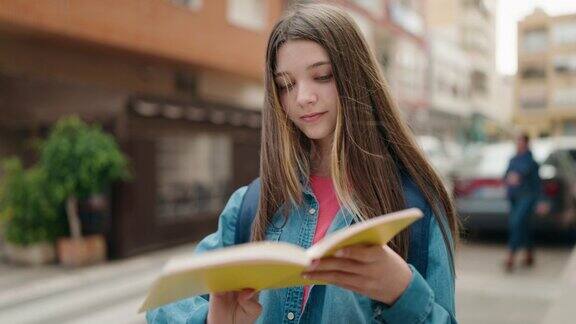 可爱的女生站在街上看书