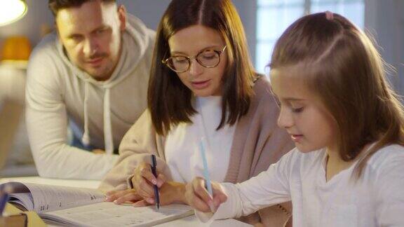 妈妈和爸爸帮助女儿做作业