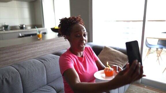 成熟女人在家用智能手机打视频电话庆祝虚拟生日