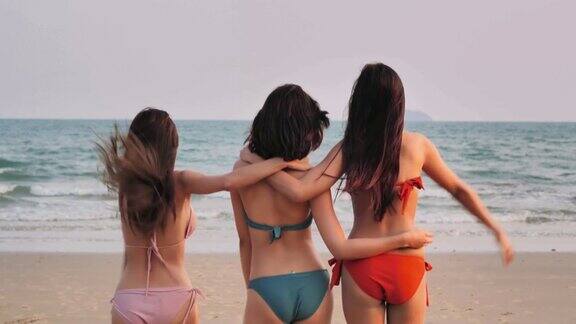 三个美丽的女孩走在一个夏天的海滩上玩一群年轻的女人在沙滩上穿着小性感的比基尼度假玩假期iStock