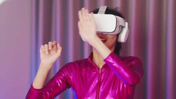 年轻的亚洲女性正在使用虚拟现实耳机霓虹灯工作室肖像虚拟现实、模拟、游戏和未来技术亚洲女人在卧室里玩游戏