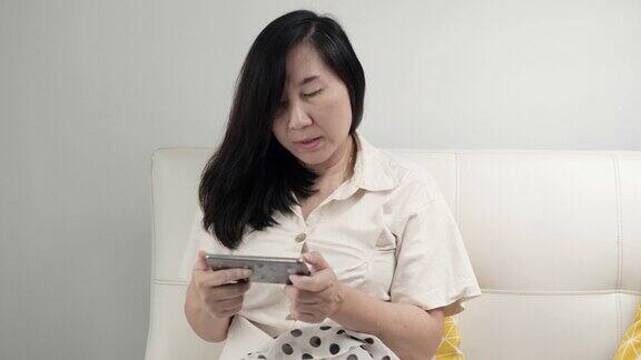 亚洲女性玩网络游戏同时在家放松生活理念