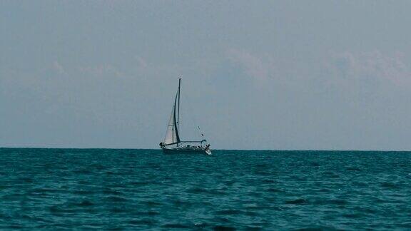 美丽的白色帆船在地平线上漂浮在海上