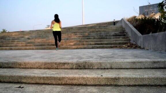 在楼梯上跑步的亚洲年轻健身女性