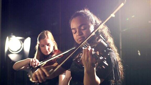 两个少女在音乐会上拉小提琴