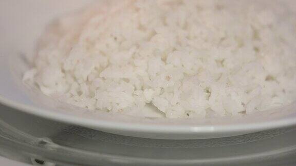 在盘子里旋转的白米饭用微波炉加热食物