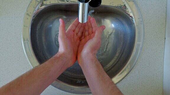 男人在金属水槽里洗手