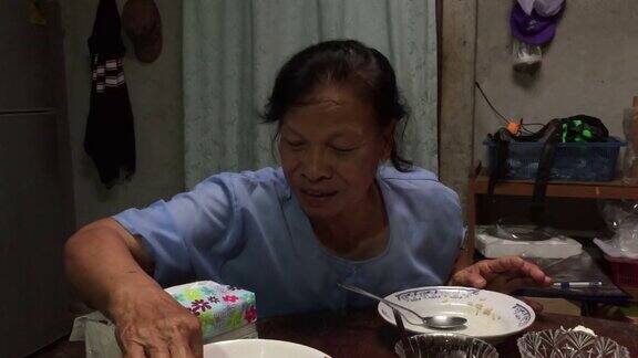 亚洲老妇人在吃米饭