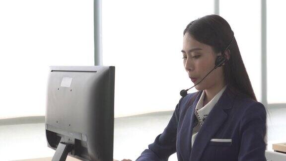 亚洲女性呼叫中心用窗光与客户交谈