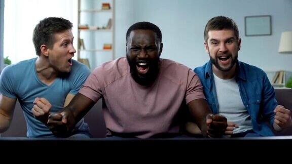 三个男人在大屏幕上观看足球比赛为最佳足球队加油