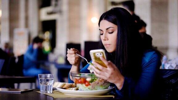 菲律宾美女一边吃沙拉一边看手机