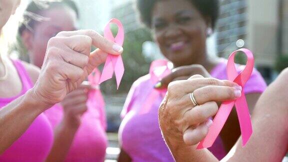 妇女们举着乳腺癌宣传丝带