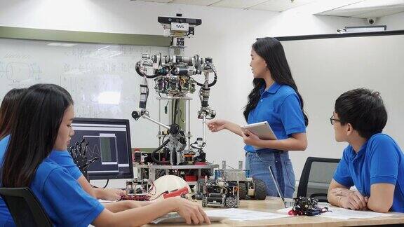 亚洲少年工程师在实验室组装和测试机器人手臂反应学生工程师编程控制器电路同步技术和协作开发机器人