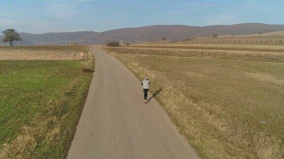 无人机拍摄的是一个年轻人在路上奔跑